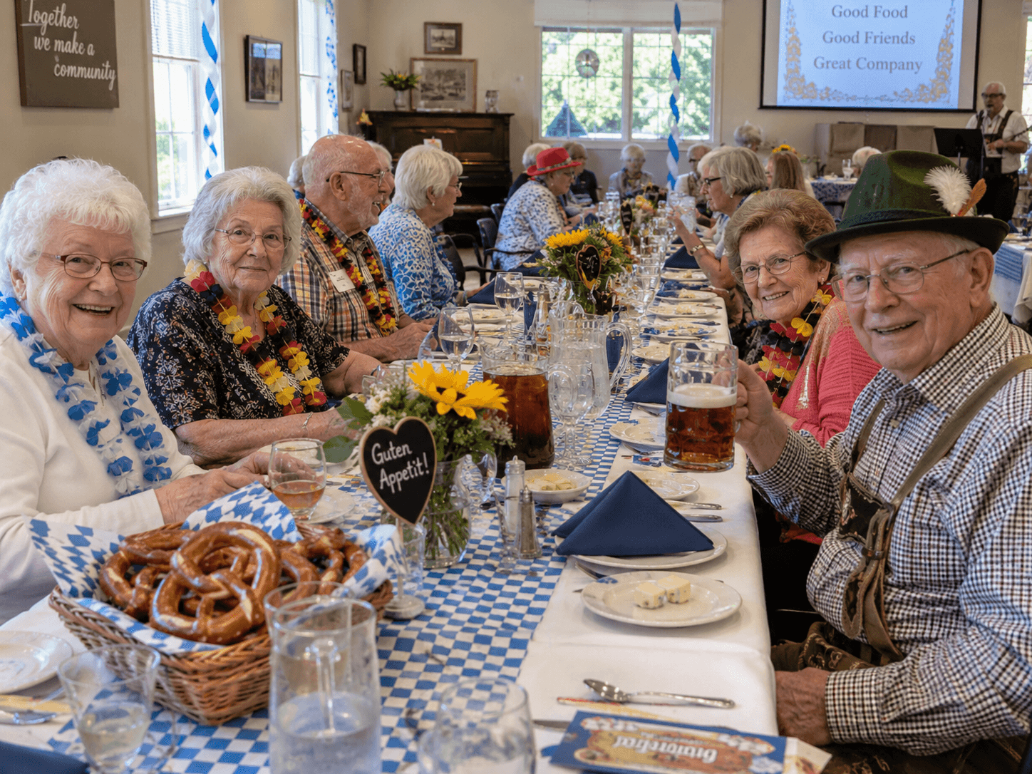 A long table set for a festive senior luncheon, with pretzels, flowers, and drinks